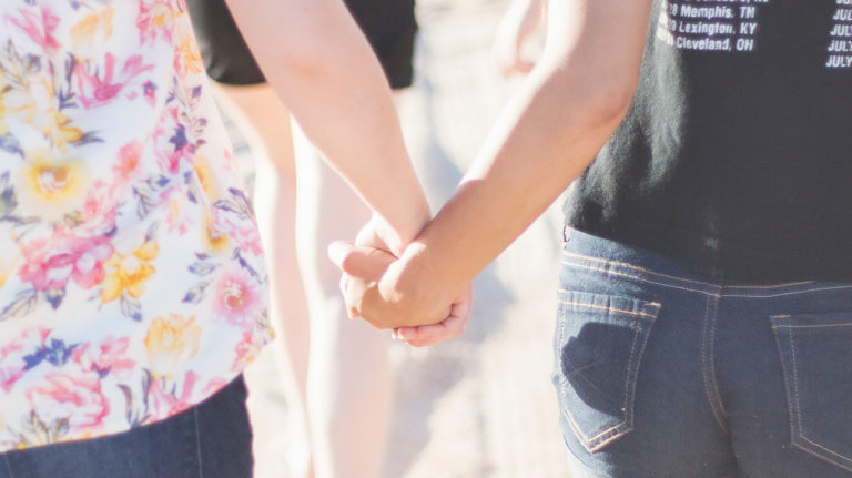 Two women holding hands.