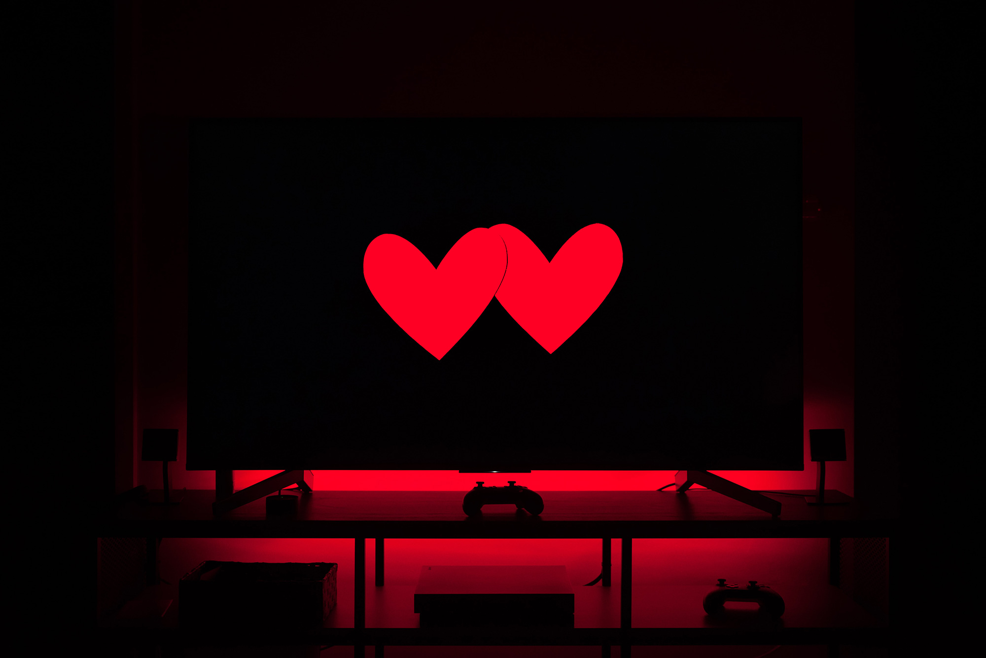 A television screen with two red paper hearts on it.